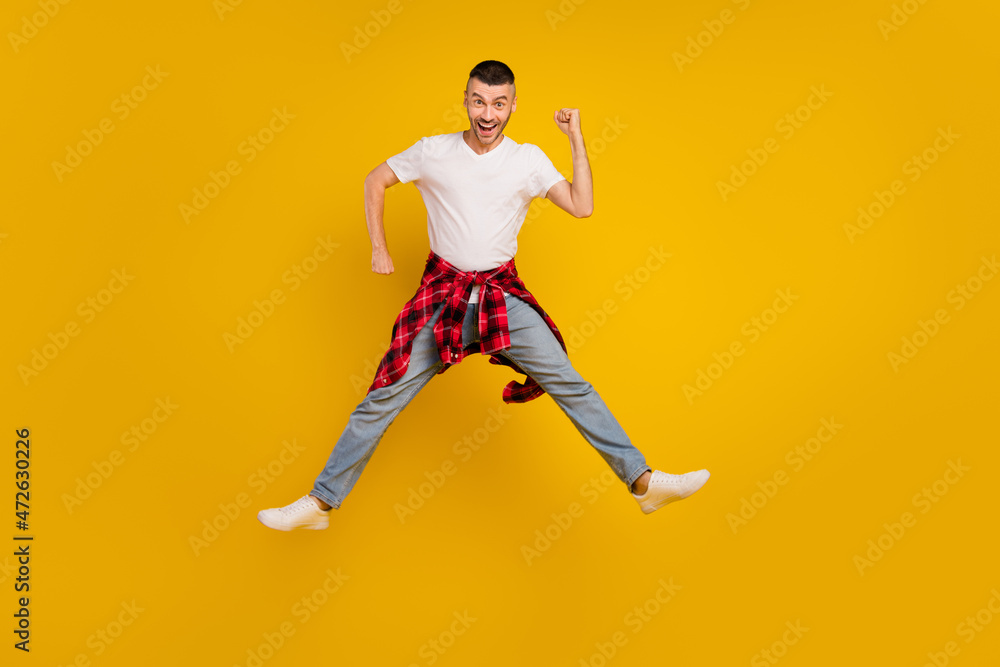 Full length body size photo man jumping fooling playful isolated vivid yellow color background