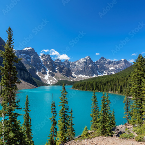 Fototapeta Naklejka Na Ścianę i Meble -  Beautiful turquoise waters of the Moraine Lake with snow-covered peaks above it in Rocky Mountains, Banff National Park, Canada.	