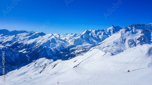 A beautiful and serene landscape of mountains covered with snow. Thick snow covers the slopes. Clear weather. Sharp slopes of the mountains covered with snow, with partially visible rocks. © Chris