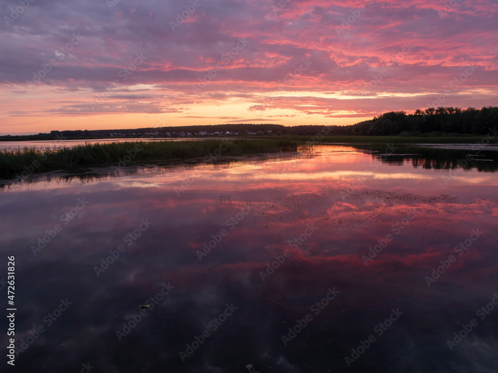 Lilac clouds and their reflection in the river at sunset