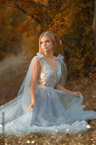Beautiful girl wearing fairy dress in autumn forest