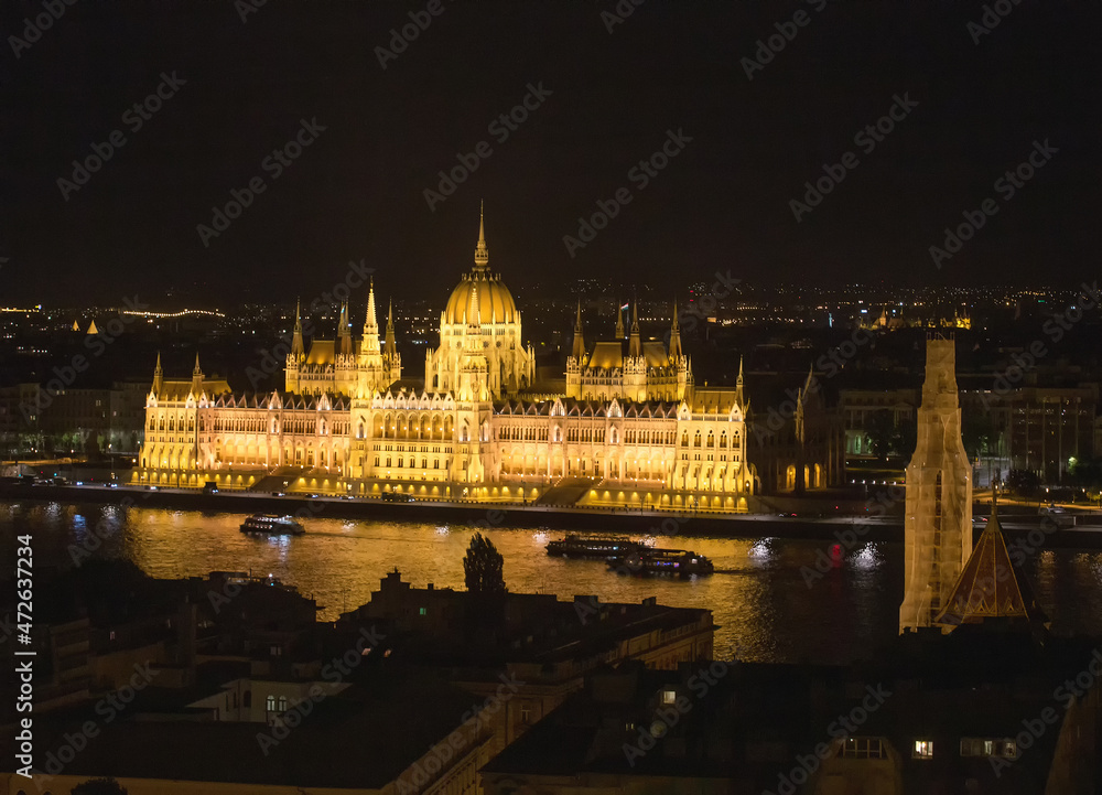 Hungarian Parliament in night Pleasure boats moving on Danube