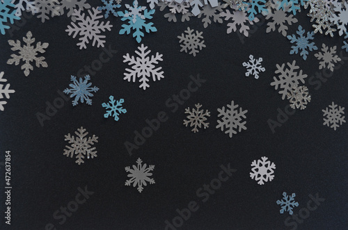 Copos de nieve cayendo en un fondo azul noche. Decoración de navidad para las fiestas en papel
