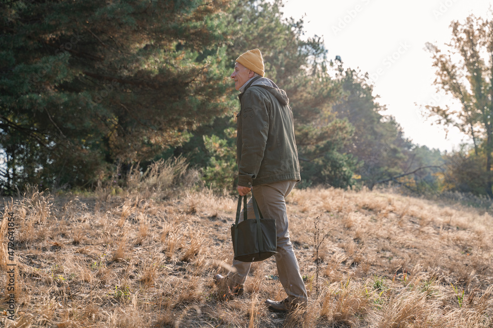 Senior man keeping bag with mushrooms and looking away Senior man keeping bag with mushrooms and looking away