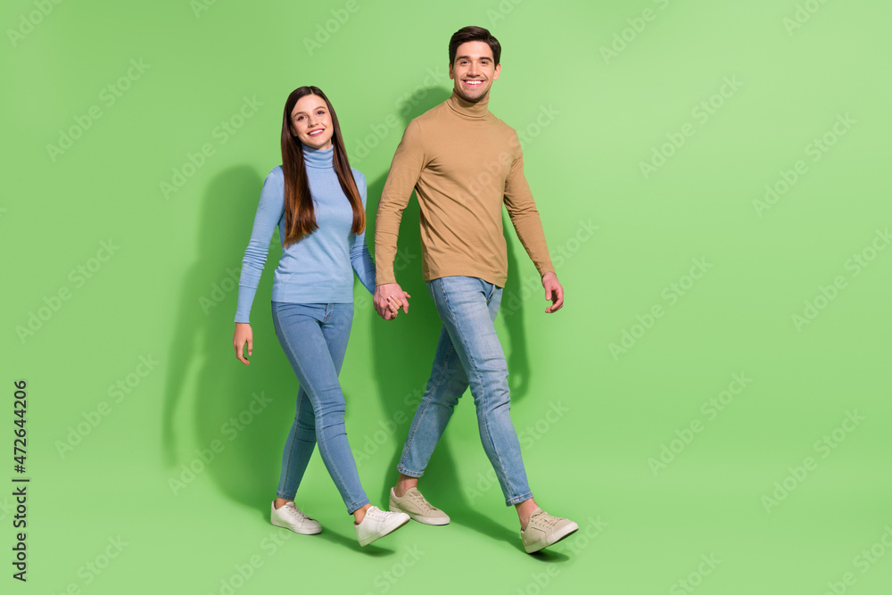 Photo of positive cheerful couple hold hands walk weekend journey wear casual outfit isolated green color background Photo of positive cheerful couple hold hands walk weekend journey wear casual outfit isolated green color background