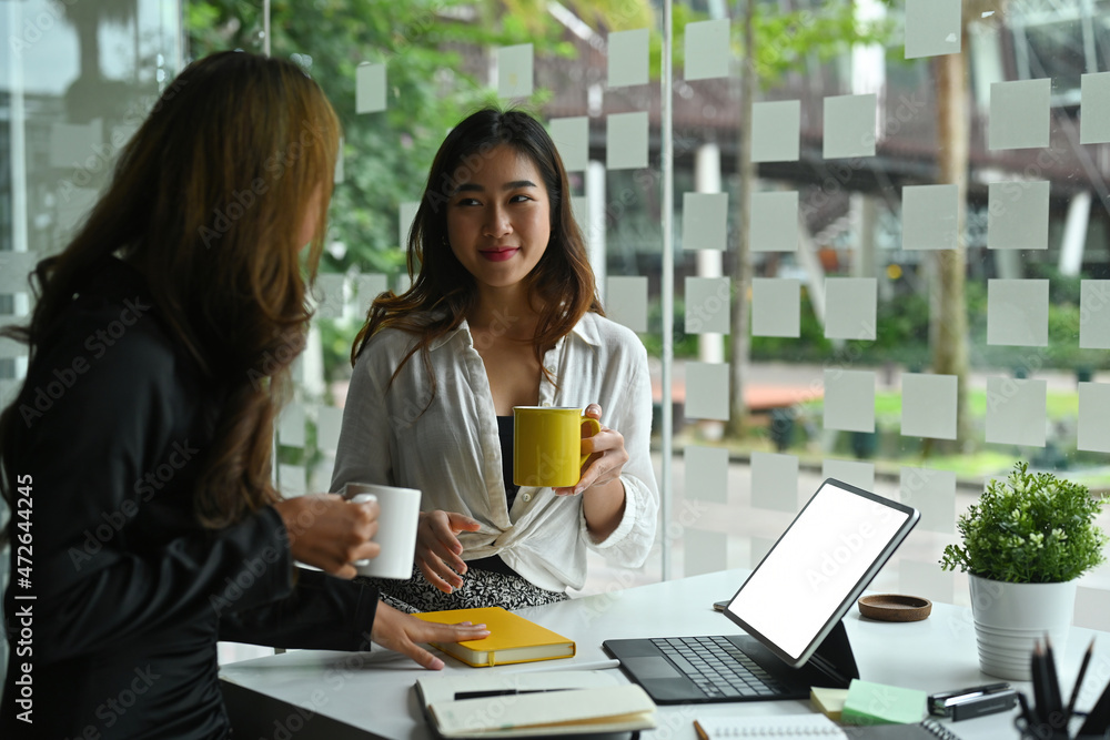 Photo of businesswomen take a break with coffee after finished meeting at the modern working desk. Photo of businesswomen take a break with coffee after finished meeting at the modern working desk.