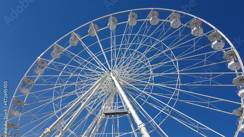 White ferris wheel isolated, blue sky.