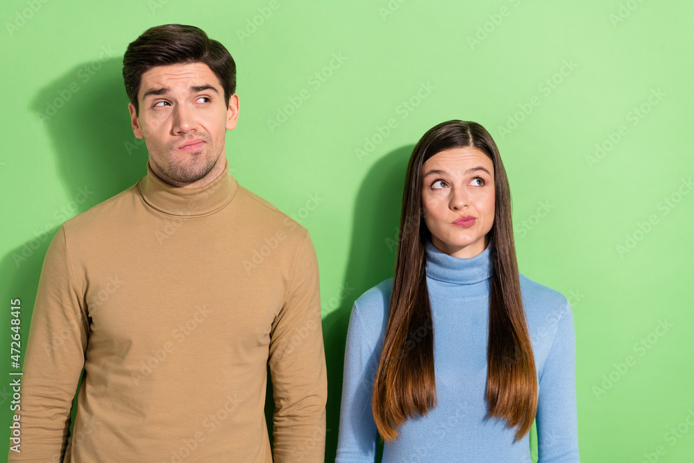 Fototapeta premium Portrait of two attractive minded people look empty space hesitate isolated on green color background