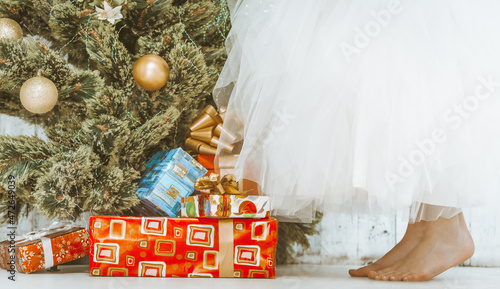 Canvas Print Girl in a White Tutu Skirt is Standing Bare Feet on the Floor by the New Year Tree