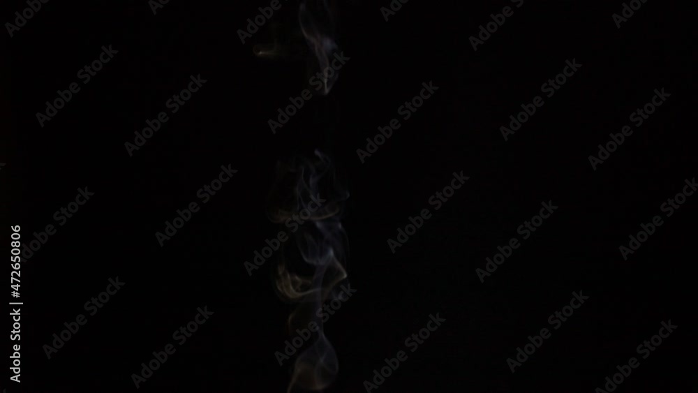 Burning incense stick, scented smoke against black background, slow motion chillout footage Burning incense stick, scented smoke against black background, slow motion chillout footage