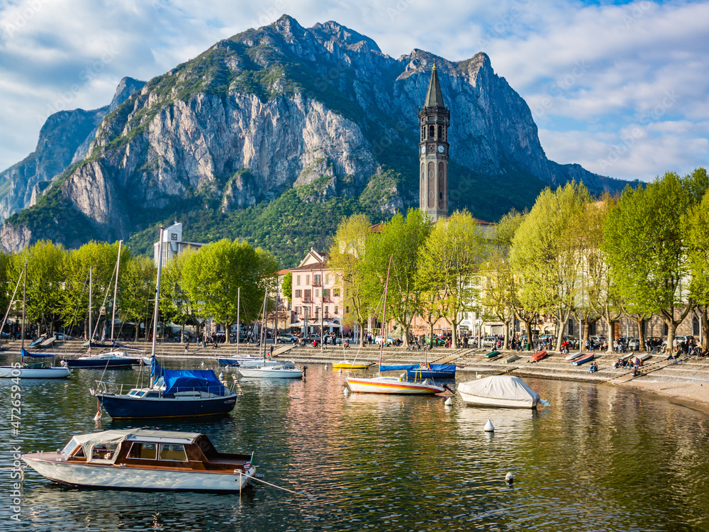 Bay of the city of Lecco in spring where we can see some boats.The road along the Lake with the walk and the tree-lined Avenue.
