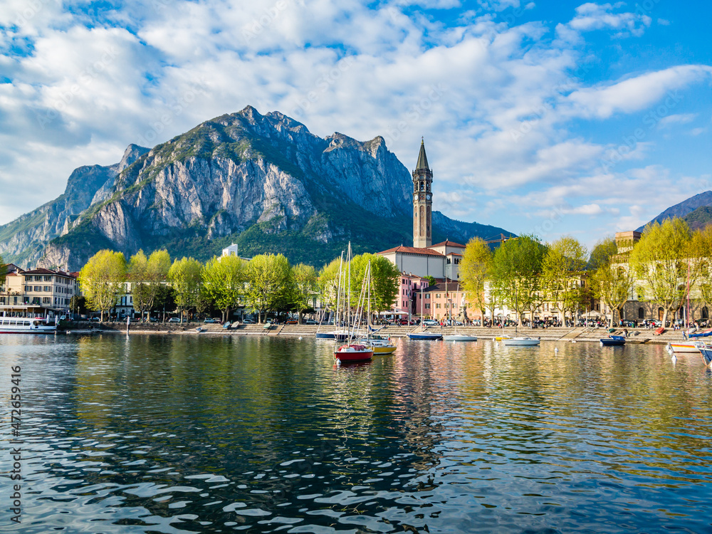 Bay of the city of Lecco in spring where we can see some boats.The road along the Lake with the walk and the tree-lined Avenue.