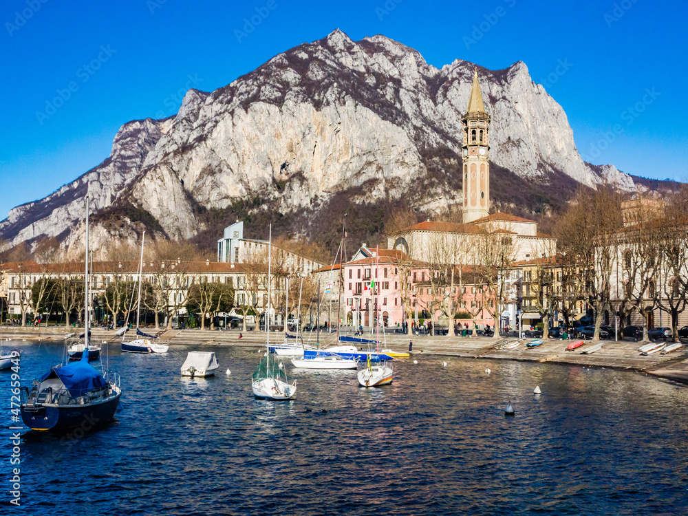 Bay of the city of Lecco in spring where we can see some boats.The road along the Lake with the walk and the tree-lined Avenue.Como lake-Lecco-Italy
