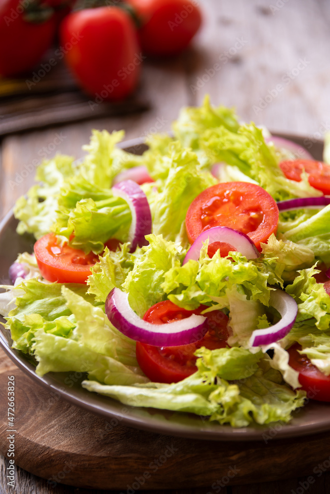 Green vegetable salad with lattuce, tomatos, onion. Healthy food concept Green vegetable salad with lattuce, tomatos, onion. Healthy food concept