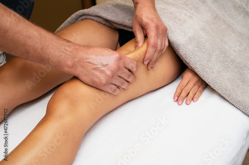 Woman getting legs lymphatic drainage massage in spa salon. Closeup. Body relaxation beauty and body care concept.