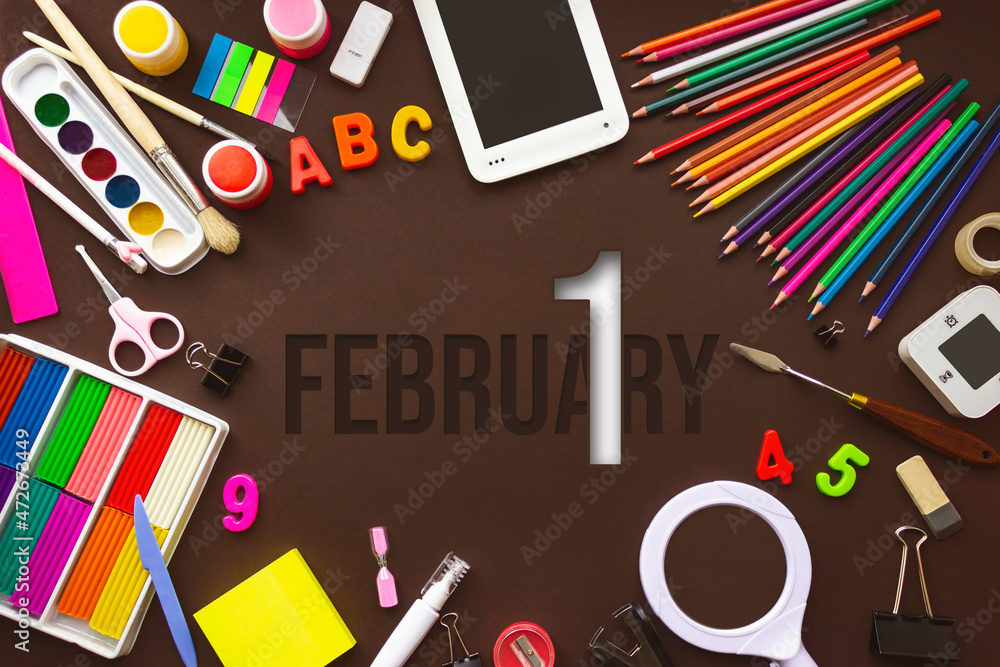 February 1st . Day 1 of month, Calendar date. School notebook and various stationery with calendar day. School and office supplies frame. Winter month, day of the year concept. February 1st . Day 1 of month, Calendar date. School notebook and various stationery with calendar day. School and office supplies frame. Winter month, day of the year concept.