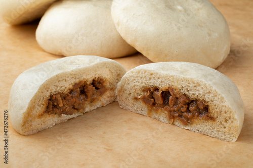 Whole and halved fresh steamed meat filled baozi close up   photo