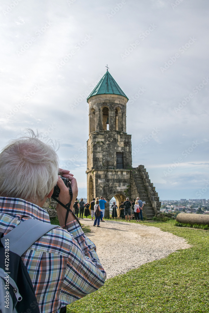 Obraz premium Blick über die Schulter eines Fotografen auf eine kleine Kapelle neben der Bagrati Kathedrale in Kutaissi, Georgien