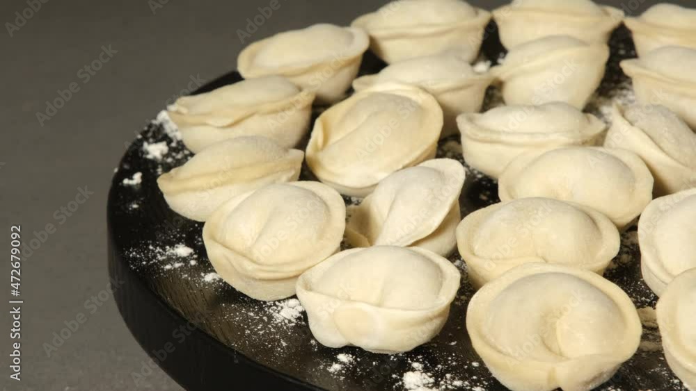 Meat dumplings on wooden black board rotating, close up Meat dumplings on wooden black board rotating, close up