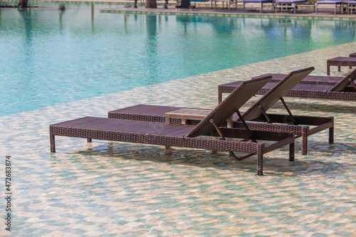 Deck chairs in the swimming pool at a tropical resort near sea in Burma, Myanmar