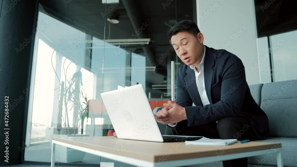 Asian male business partner talking remotely on video call using webcam. Businessman man in a suit entrepreneur, manager or office worker meeting online or conference. Chat with colleagues with laptop Asian male business partner talking remotely on video call using webcam. Businessman man in a suit entrepreneur, manager or office worker meeting online or conference. Chat with colleagues with laptop