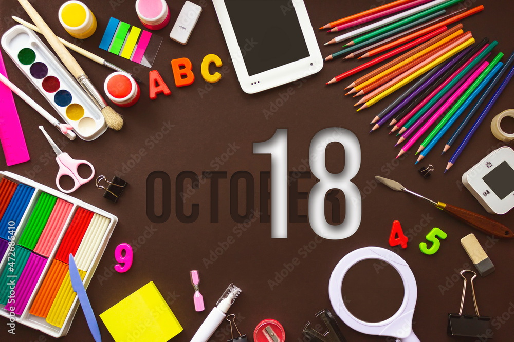 October 18th. Day 18 of month, Calendar date. School notebook and various stationery with calendar day. School and office supplies frame. Autumn month, day of the year concept.