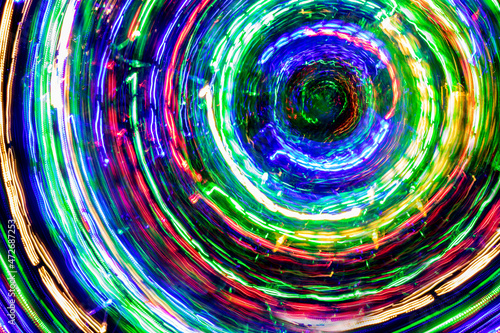 The round of blurred lines of color lights on dark background. Colorful lights blurred by motion.