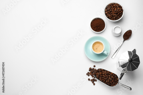 Flat lay composition with coffee grounds and roasted beans on white background, space for text photo
