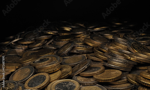Viele Euro Münzen vor schwarzem Hintergrund.
