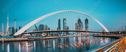 Obraz na płótnie colorful sunset over Dubai Downtown skyscrapers and the newly built Tolerance bridge as viewed from the Dubai water canal w salonie