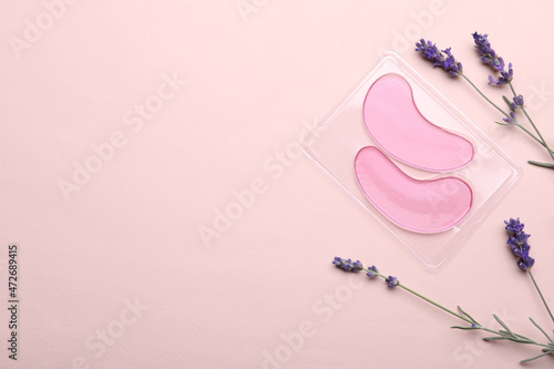 Tela Package with under eye patches and lavender flowers on light pink background, flat lay