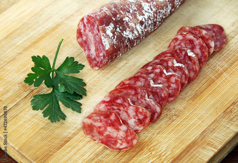 Sliced Spanish traditional sausage Fuet on wooden board. Sliced Spanish traditional sausage Fuet on wooden board.