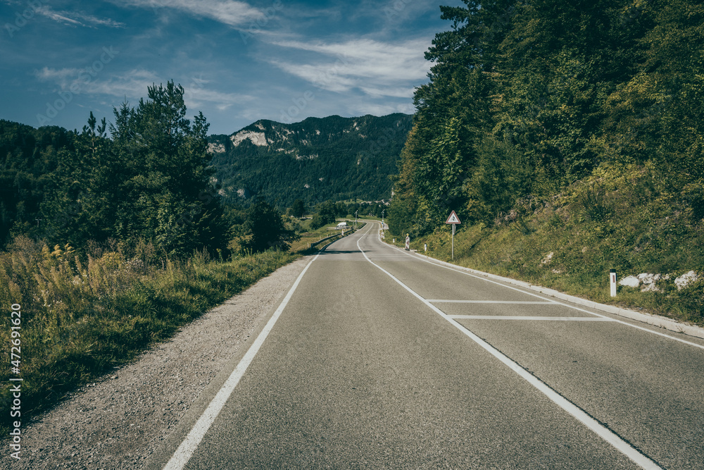 Fototapeta premium landscape with a road between mountains and meadows