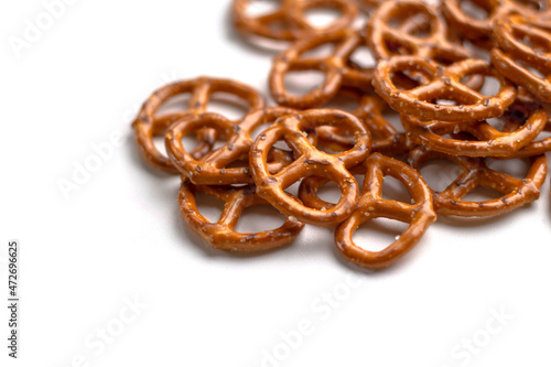 Crispy salty pretzels lie scattered on a white background. Top view. Concept: quick snack, food photography, holidays and vacations, cafes and bistros, Christmas food.