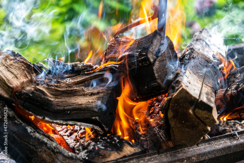 Firewood burns with a yellow flame, emitting heat.