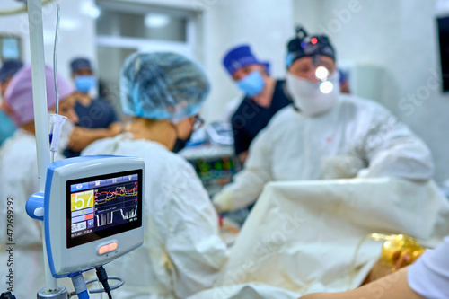 surgeon in the operating room performs an operation on a patient photo