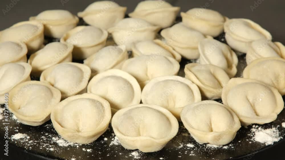Meat dumplings on wooden black board rotating, close up Meat dumplings on wooden black board rotating, close up
