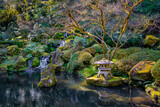 A pagoda lantern sculpture and a waterfall in a Japanese garden in Porltand Oregon