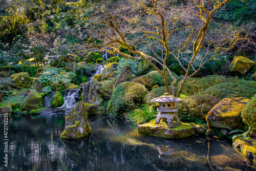 A pagoda lantern sculpture and a waterfall in a Japanese garden in Porltand Oregon
