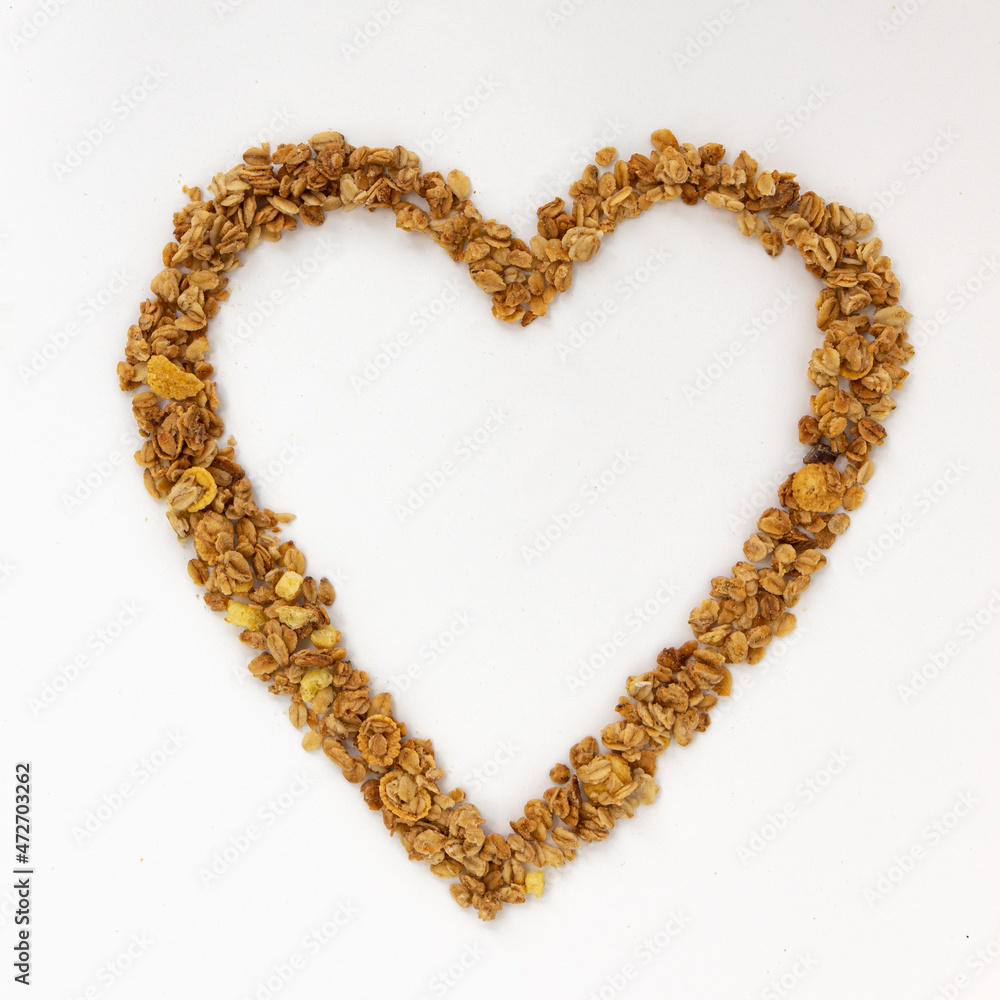 Obraz premium heart of crunchy granola on white background, top view