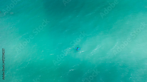 homem em praia com águas cristalinas vista de drone 
