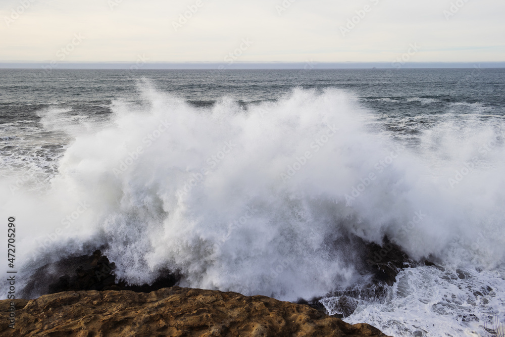 A huge wave hitting the rocks on the Pacific coast