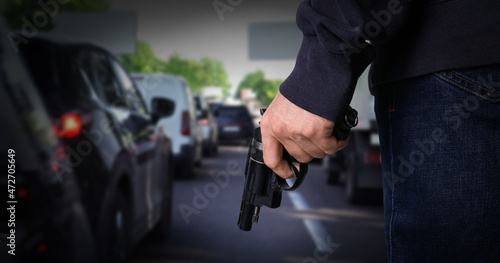Man with gun near cars outdoors, closeup