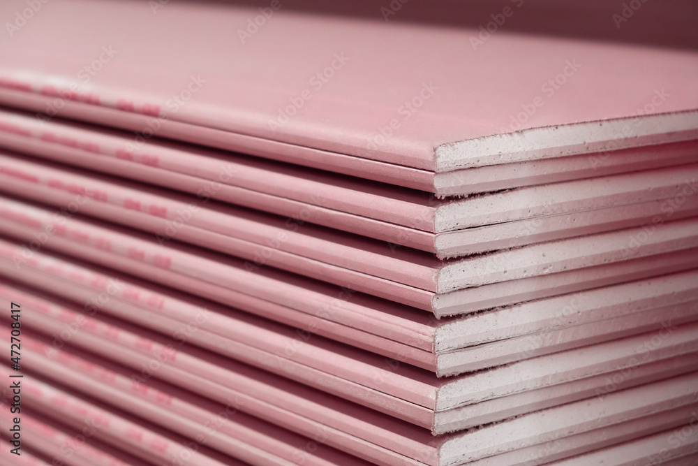 Stack of Plasterboard Fire Resistant gypsum. Drywall board cardboard surface Panel Type DF for indoor concrete walls prepared for construction Stack of Plasterboard Fire Resistant gypsum. Drywall board cardboard surface Panel Type DF for indoor concrete walls prepared for construction