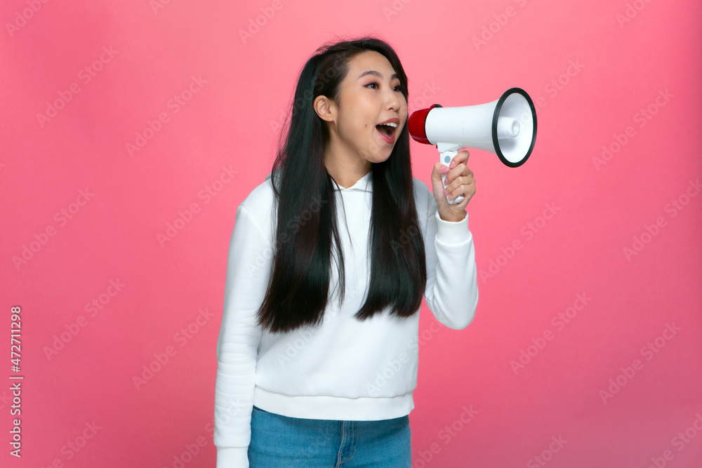 Positive asian girl shouting in megaphone, announce sale with loudspeaker, cheering up, making advertisement Positive asian girl shouting in megaphone, announce sale with loudspeaker, cheering up, making advertisement