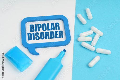 On the white and blue surface are a marker, tablets and a plate inside which the inscription - BIPOLAR DISORDER
