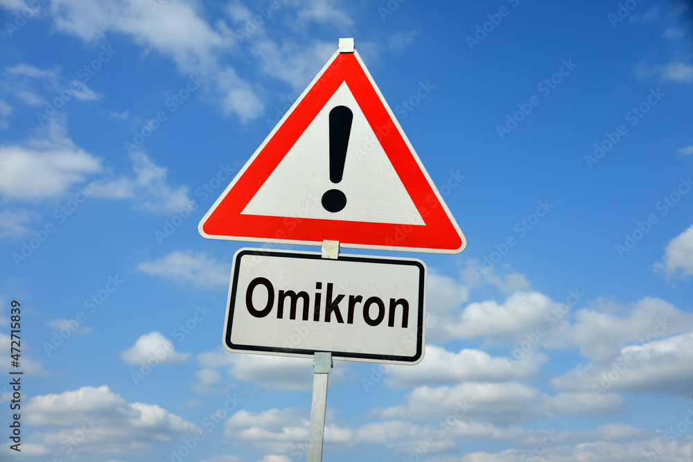 Hamburg, Germany - November 29, 2021: German Traffic warning sign with the note Omikron - symbolizes the danger from a new variant named Omicron or Omikron in German-speaking countries Hamburg, Germany - November 29, 2021: German Traffic warning sign with the note Omikron - symbolizes the danger from a new variant named Omicron or Omikron in German-speaking countries