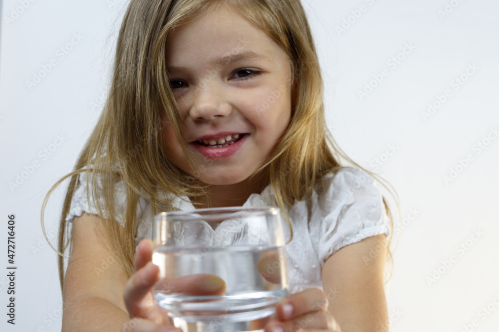 Portrait of a smiling little girl offering a glass of pure water. Portrait of a smiling little girl offering a glass of pure water.