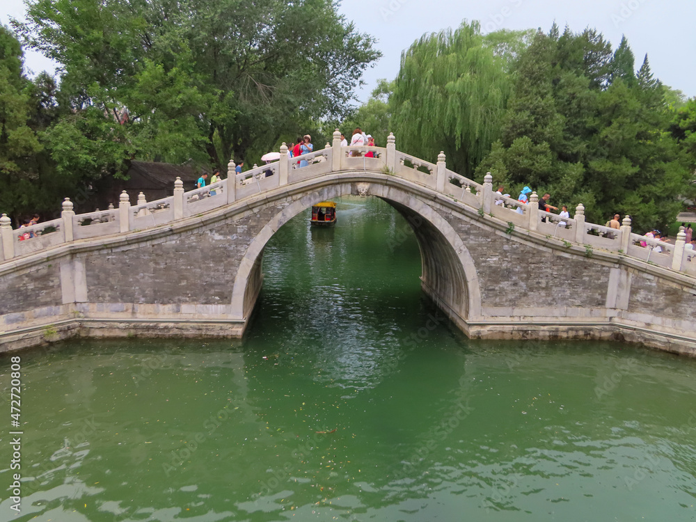 Obraz premium The Ornate Arch Bridge Allowing Guests to Cross Over Kunming Lake on the Path around the Summer Palace