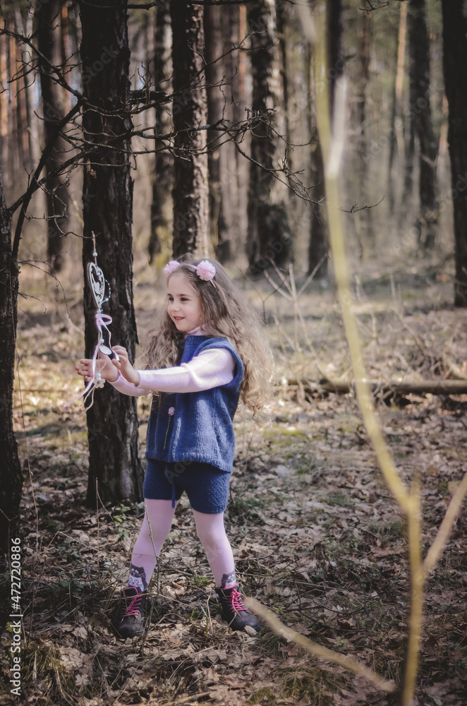 Picture of an ethnic styled little girl with long hair in a headband playing in the forest Picture of an ethnic styled little girl with long hair in a headband playing in the forest